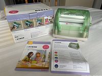 Photo showing Xyron Creative Station laminator along with original packaging box and product brochure.