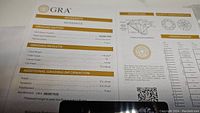 GRA certification document showing 2 carat moissanite grading details including color D, clarity VVS1, and 8mm size.