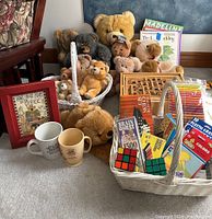 Full lot showing bears, books, framed art, mugs, baskets with crayons and games.