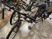 Full view of Navajo Nishiki mountain bike in maroon with fender and knobby tires.