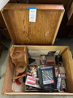 Open wooden box showing assorted tools and smaller boxes inside.