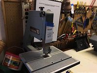 Front view of Delta 10 scroll saw showing ribbed metal work table and blade area.