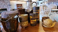 Overall view of the pottery collection showing the large jug, vases, hand thrown piece, snail sculpture and others.