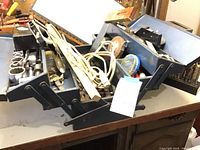 Open metal tool box showing sockets, hand tools, clamps, cord