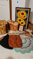 Overview of all items: vinyl ottoman, seagrass tote, framed art, handbags, magazine rack, crochet rug