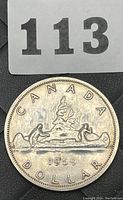 Obverse side of the coin showing the 1959 date, canoe design with two paddlers and 'CANADA DOLLAR' text.