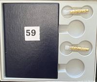 Black presentation case holding six Canadian coins in plastic holders and two small vials containing gold flakes.