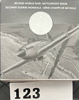 Obverse of coin in original box showing aircraft from Battle of Britain and text indicating Second World War Battlefront Series.