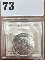 Obverse of the 1949 Canadian silver dollar showing King George VI's profile with certification label.