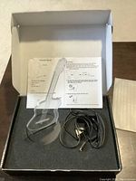 3D guitar-shaped transparent acrylic lamp on black base with power cord and instructions inside box.