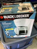 Photo of the boxed Black & Decker 12-cup programmable coffee maker showing front and top of box with product image and branding.