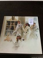 Front cover of Cheap Trick Dream Police album showing band members in white police uniforms in a room with animal decor and window in background.
