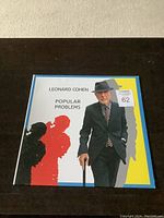 Front cover of Leonard Cohen Popular Problems vinyl record album LP showing artwork and title.