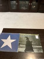 Both vinyl albums laid flat on a table showing their front covers: 'After the Gold Rush' with white star on blue and 'Hawks and Doves' with monochrome person walking image.