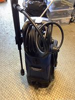 Front view of unit showing coiled high-pressure hose and integrated hose reel