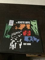 Front cover of The Beastie Boys Root Down vinyl record album showing colorful band member collage and title.