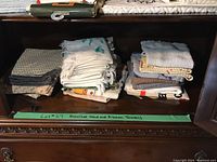 Photo of multiple folded towel stacks on wood shelf