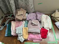 Overhead view of assortment of different towels neatly stacked and folded, showing color variety and fabric texture.