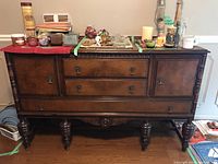 Full front view of the wood buffet sideboard with objects on top.