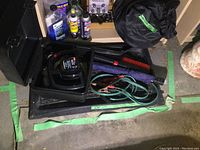 Broad view of all items including box, cables, bottles of fluid, brushes, and car cover bag