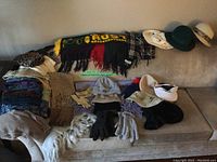 Full view of collection on couch showing scarves, mitts, gloves, hats, and shawls