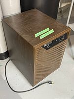 Brown Mastercraft D28 dehumidifier angled view showing side and top with power cord and labels.