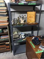 Full view of the metal shelving unit with various items on the shelves (not included in sale).