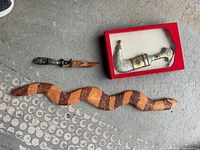 Carved wooden snake walking stick, decorative dagger with sheath in red box, and small carved knife.