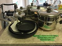Photo showing all pots and pans set including steamer pot on kitchen counter.