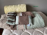 Overview of queen size foam topper, comforter, pillow cases, shams, bed skirt, and small pillow on mattress