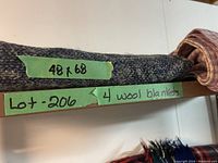Image of rolled dark gray wool blanket with size label 48 x 68 inches and lot label for 4 wool blankets.