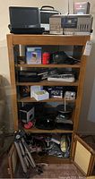 Maple shelving unit filled with various electronics and accessories