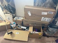 Lot overview showing unopened boxed items, garden stakes, and lights in packaging.