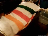 Multicolored weighted blanket with orange, red, green, and white stripes folded on a surface