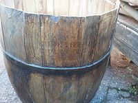 Side view of the full size oak barrel showing natural wood staves with metal bands and original stamp on the side.