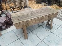 Top view of old wooden saddle bench showing plank top and aged wood texture.