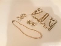 Photo showing the pearl necklace, two pairs of pearl clip-on earrings, and a beaded handbag with vine pattern.