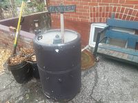 Front view of the vintage wringer washer machine planter showing its round body and wear marks.