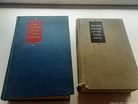 Blue hardcover book titled 'The Collapse of the Third Republic' and beige hardcover book titled 'The Rise and Fall of the Third Reich' side by side. Beige book shows wear at the corner.