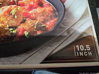 Close-up of skillet in use with food, showing 10.5 inch size marking on packaging.