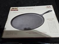 Boxed Parini 10.5-inch round griddle packaging with handle image.