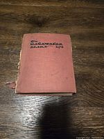 Closed view of the red hardcover 1908 Wannamaker diary book showing worn edges and faded title on the front cover.