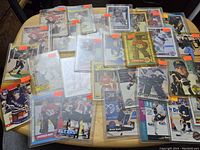 Overview photo of 29 vintage hockey cards laid out on a table, cards mostly in plastic sleeves with price stickers visible