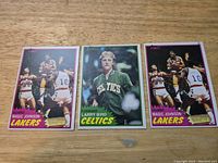Photo showing front sides of 3 basketball cards: 2 Magic Johnson and 1 Larry Bird from 1981 Topps series.