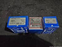 Three boxes of 1 1/2 inch pan head combo tapping screws side by side showing front and side labels.