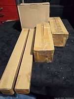 Four brown cardboard boxes containing the unopened auger sets.