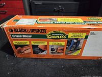 Box with Black & Decker branding and product features including cordless rechargeable operation, precision sharpened blades, lock-off switch, and charger compatibility.