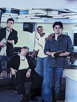 Photo of five men in a modern indoor setting, printed on vintage print paper.