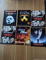 Top view of front sides of all six promo cards arranged in two rows, showing movie titles and cover images.