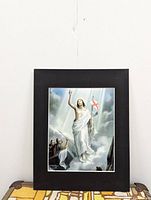 Front view of vintage matted religious print depicting Jesus Christ with a flag against a cloudy sky.